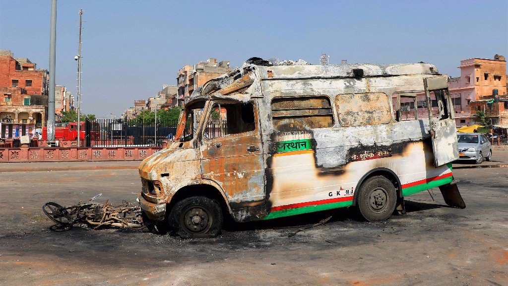 A torched vehicle after clashes broke out between locals and police in Jaipur. Credit: PTI