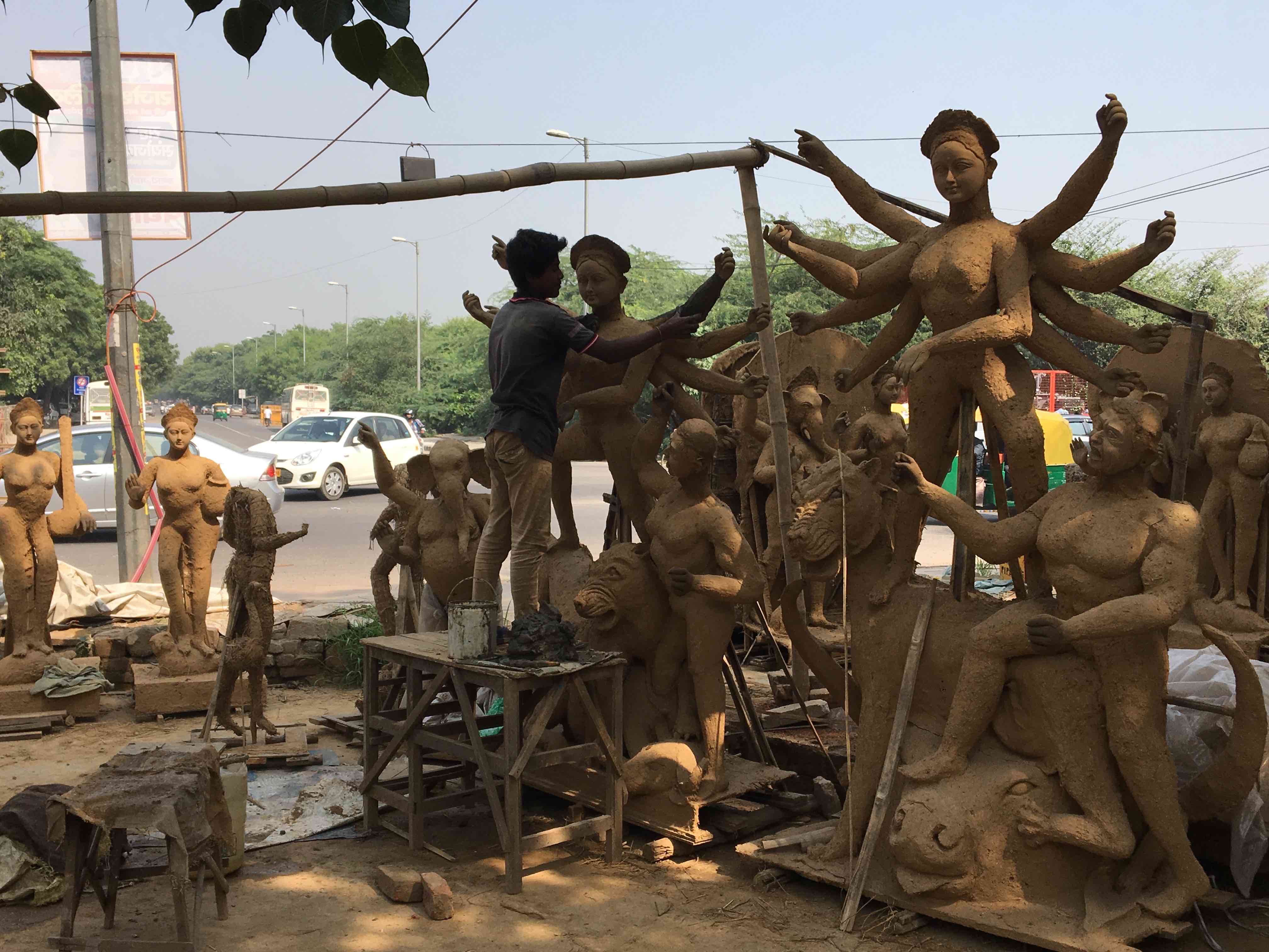 Gopal Malakar, son of artisan Tapan Malakar, putting the finishing touches to the devi’s idol at the penultimate stage, before it gets the final coat of clay. Credit: Revathi Krishnan