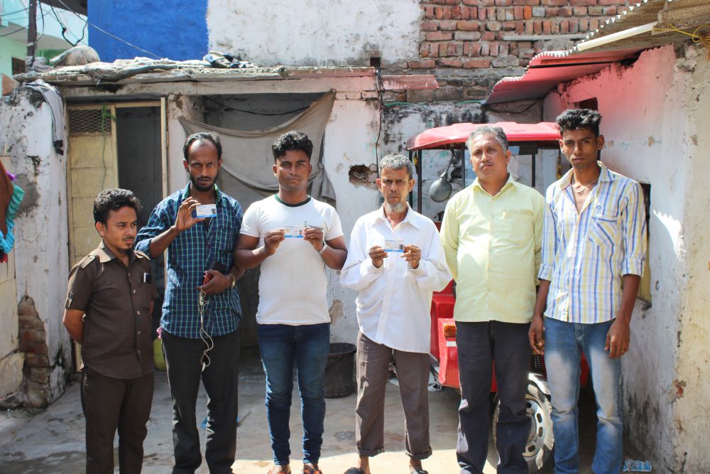 Rohingya refugees holding their refugee card in Jaipur colony. Credit: Shruti Jain