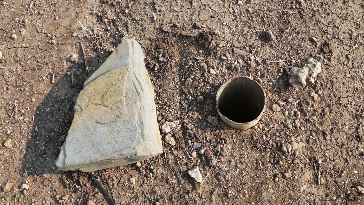 A failed borewell in Nagarur and the stone that is used to cover the opening.