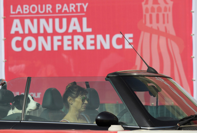 A woman drives past the Labour party Conference venue with a dog on the back seat of her car in Brighton, Britain, September 24, 2017. Credit: Reuters