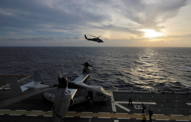 A Navy MH-60S Seahawk helicopter heads out at sunrise on a search and rescue mission from the USS Kearsarge as MV-22 Ospreys prepare on the flight deck as operations to assist hurricane-ravaged St. Croix and Puerto Rico begin, in the Caribbean Sea, September 21, 2017. Credit: Reuters