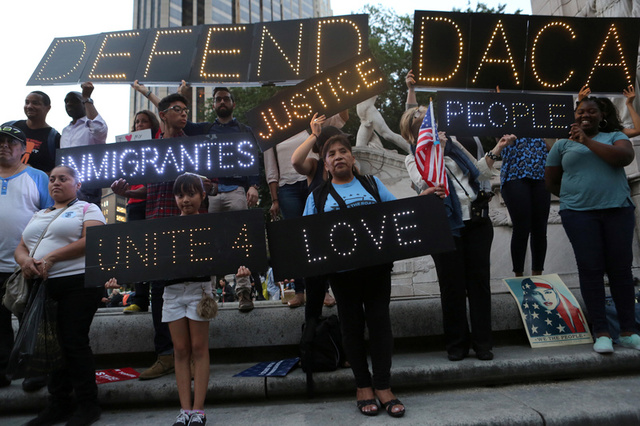 People hold signs against U.S. President Donald Trump's proposed end of the DACA program that protects immigrant children from deportation at a protest in New York City, U.S., August 30, 2017. Credit:Reuters