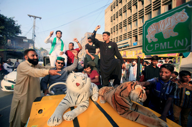 Supporters of the PMLN political party cheer on their candidate outside a polling station in Lahore, Pakistan September 17, 2017. Credit: Reuters