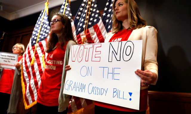 Women hold signs during a press conference held by U.S. Sen. Bob Casey, D-Pa., to speak out against the latest Republican effort to repeal Obamacare on Capitol Hill in Washington, U.S., September 25, 2017. Credit: Reuters