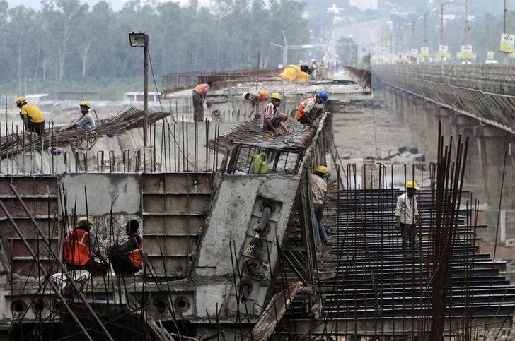Labourers work at the construction site of a highway bridge on the outskirts of Jammu August 31, 2013. Credit: Reuters/Mukesh Gupta/Files