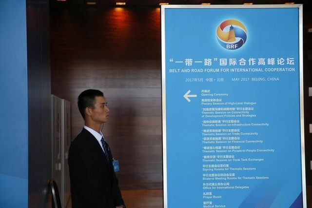 A staff member stands next to a sign for the Belt and Road Forum at the National Convention Centre in Beijing, China May 13, 2017. Credit: Reuters/Stringer/Files