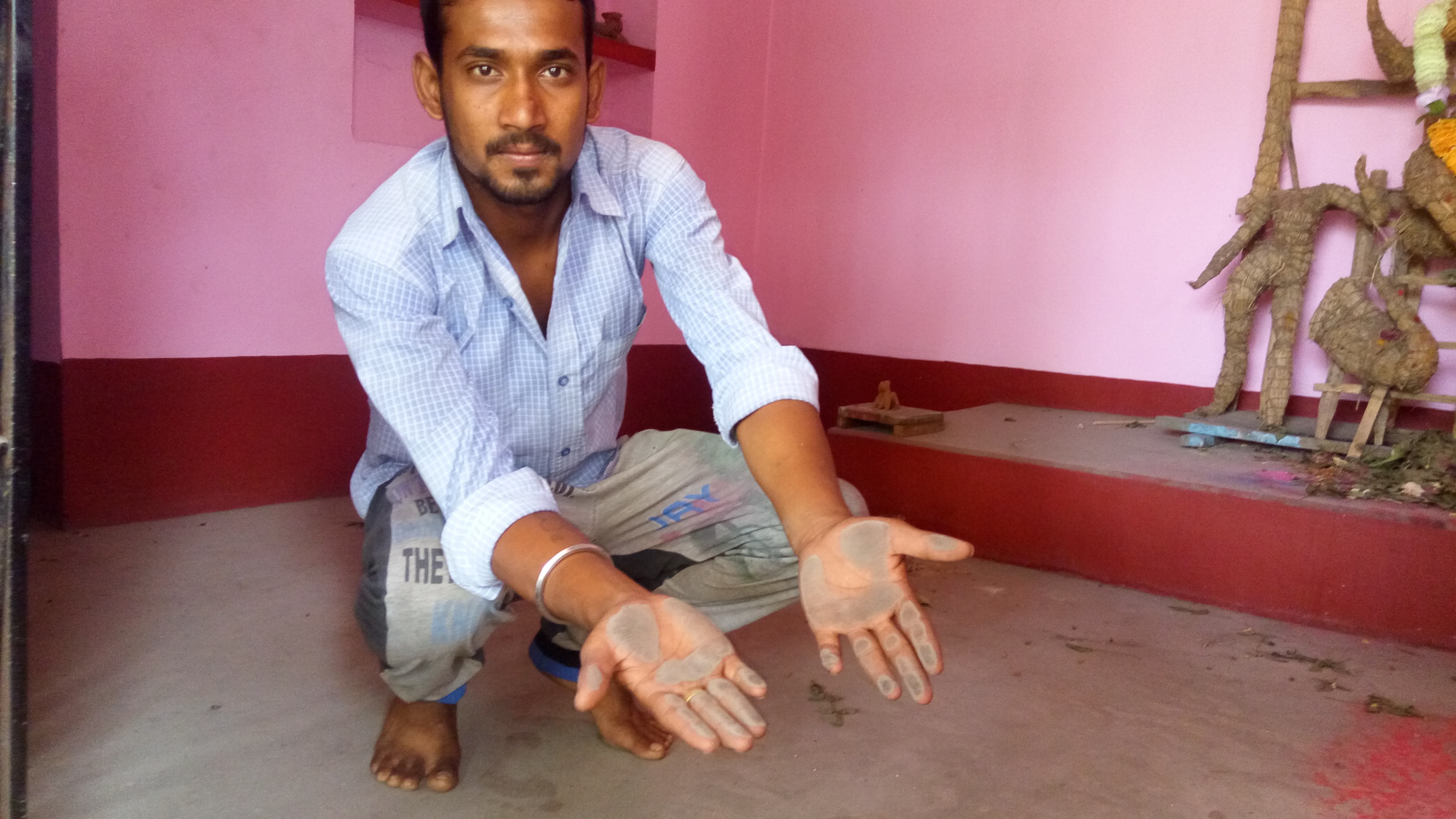 Dinamoy Badhakor, a resident of the village, shows the ash from the power plant. Credit: G. Arora