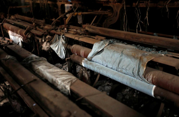 Fabric for shirts is seen on a power loom machine inside a closed-down factory in an industrial area on the outskirts of Mumbai, India, October 5, 2017. Credit: Reuters/Danish Siddiqui