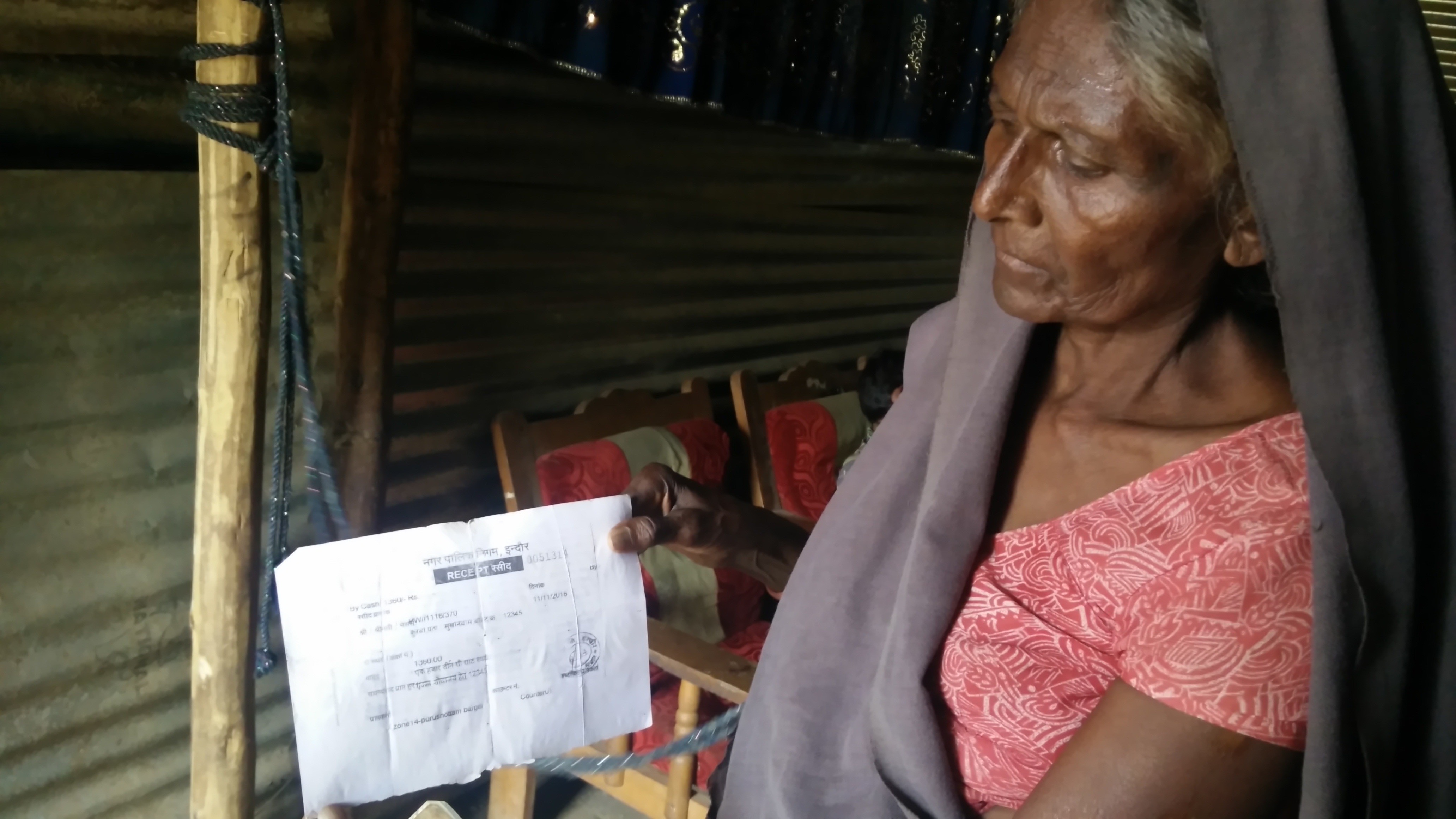 Sunita Bhabhar showing the receipt of payment made to the Indore Municipal Corporation for building a toilet in her house in Sukhniwas road slum. Credit: Sukanya Shantha