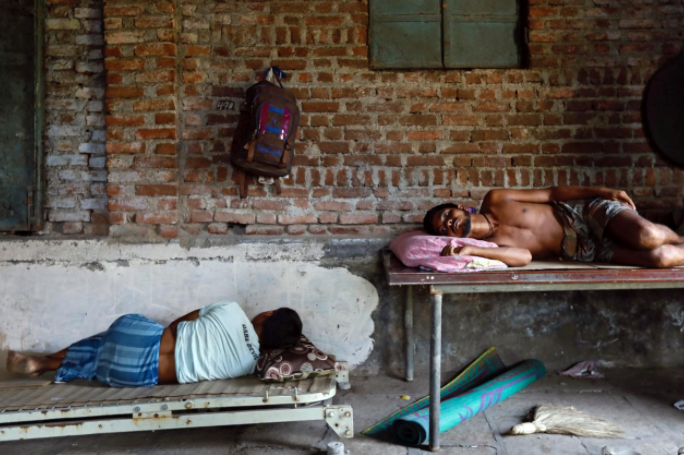 Workers rest inside a closed-down factory in an industrial area on the outskirts of Mumbai, India, October 5, 2017. Picture taken October 5, 2017. REUTERS/Danish Siddiqui