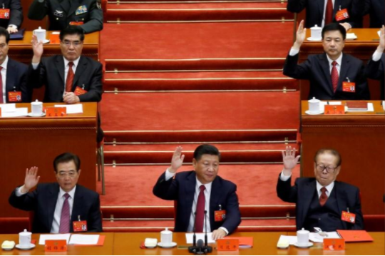 Former Chinese president Hu Jintao, Chinese President Xi Jinping and former Chinese president Jiang Zemin raise their hands as they take a vote at the closing session of the 19th National Congress of the Communist Part of China in Beijing, China, October 24, 2017. Credit: Reuters/Thomas Peter