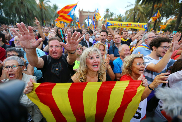 People react as they watch a session of the Catalonian regional parliament on a giant screen at a pro-independence rally in Barcelona, Spain, October 10, 2017. Credit: Reuters