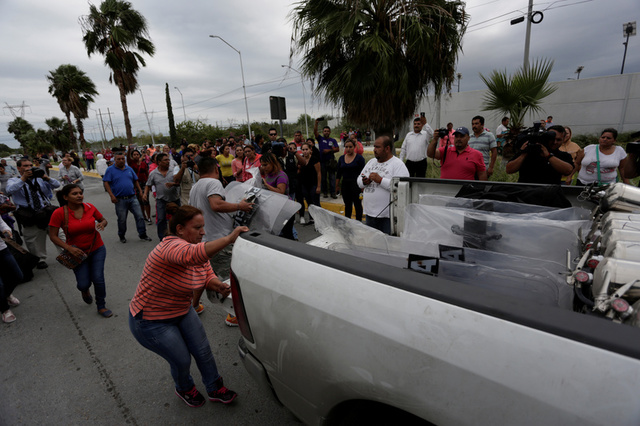 Relatives of inmates grab police shields from a truck arriving at Cadereyta state prison after a riot broke out at the prison, in Cadereyta Jimenez, on the outskirts of Monterrey, Mexico October 10, 2017. Credit: Reuters