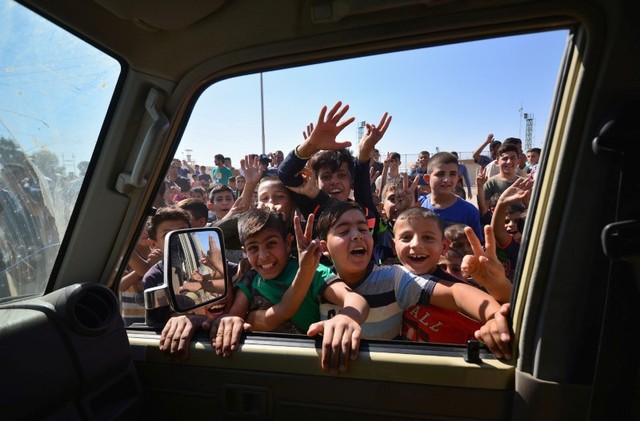 Iraqi boys gather on the road as they welcome Iraqi security forces members advancing in military vehicles in Kirkuk, Iraq October 16, 2017. Credit: Reuters