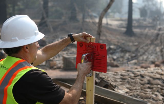 An official from the Napa County building department red tags a home destroyed by wildfire in Napa, California, U.S., October 13, 2017. Credit: Reuters
