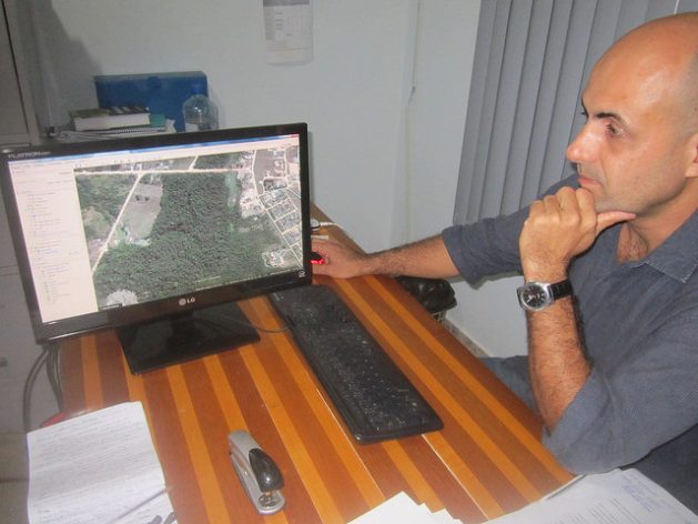 Pedro Correa, director of the environment in the Paranaita city government, looks at a photo of the city surrounded by forests, on his computer screen. Originally from the southern state of São Paulo, he worked for a few months on the construction of the Teles Pires hydropower dam and decided to stay in this town because he likes the quality of life. Credit: IPS