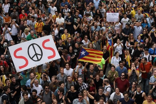People hold up placards during a demonstration two days after the banned independence referendum in Barcelona, Spain Credit: Reuters