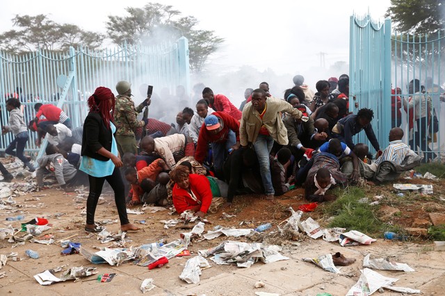 People fall as police fire tear gas to try control a crowd trying to force their way into a stadium to attend the inauguration of President Uhuru Kenyatta at Kasarani Stadium in Nairobi, Kenya November 28, 2017. Credit: Reuters/Baz Ratner