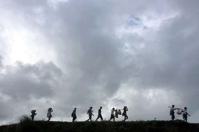 People displaced by violence walk in the banks of Mayu river with their belongings while moving to another village, in Buthidaung in the north of Rakhine state, Myanmar September 13, 2017. Credit: Reuters/Stringer/Files