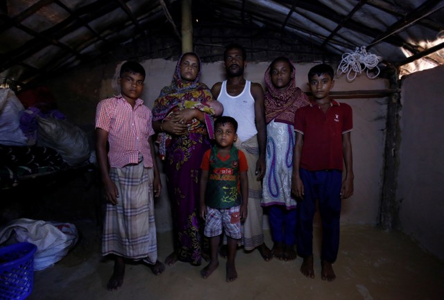 Mohammad Zubair (L), 14, a Rohingya refugee boy, poses for a picture along with his mother Fatima Begum (2nd L), Father Nur Kobir (3rd R), sister Anu Ara (2nd R), brother Mohammad Harris (R) and brother Mohammad Zasangir (C) inside their temporary shelter at Kutupalong refugee camp near Cox's Bazar, Bangladesh, November 12, 2017. Credit: Reuters/Navesh Chitrakar