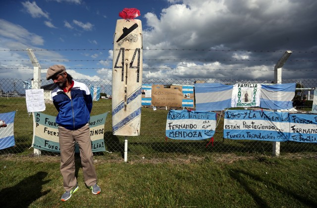 A man stands in front of signs in support of the 44 crew members of the ARA San Juan submarine missing at sea, placed on a fence outside the Argentine Naval Base where the submarine sailed from, in Mar del Plata, Argentina November 20, 2017. Reuters/Marcos Brindicci