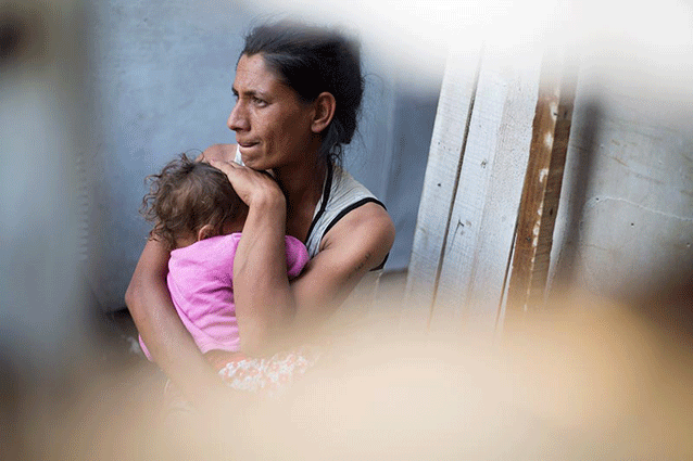 Fatmira Mustafa, a mother of four, collects rubbish from bins for a living. She has been anxiously waiting for the day when the owner of the plot on which her family is squatting will knock on her door to claim the land. Credit: UNHCR/Roger Arnold