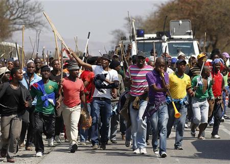 Mineworkers take part in a march outside the Anglo American mine in South Africa's North West Province, September 12, 2012. Labour unrest sweeping through South Africa's mining sector hit top world platinum producer Anglo American Platinum on Wednesday, with stick-waving miners blockading roads leading to shafts and calling for a shut-down of operations.Credit: Reuters/Siphiwe Sibeko