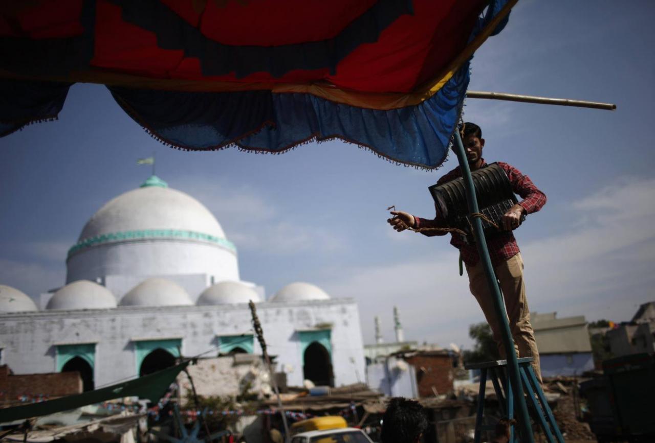 A man uninstalls a light from a temporary tent in front of a mosque in a Muslim-dominated area in Ahmedabad March 3, 2014. Credit: Reuters/Ahmad Masood/Files