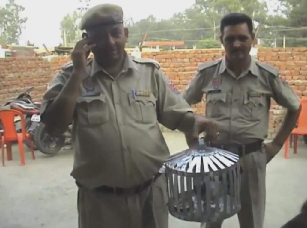 Policemen in Pathankot with the pigeon that has been detained on suspicion of terrorist links. Credit: Screen grab from rt.com