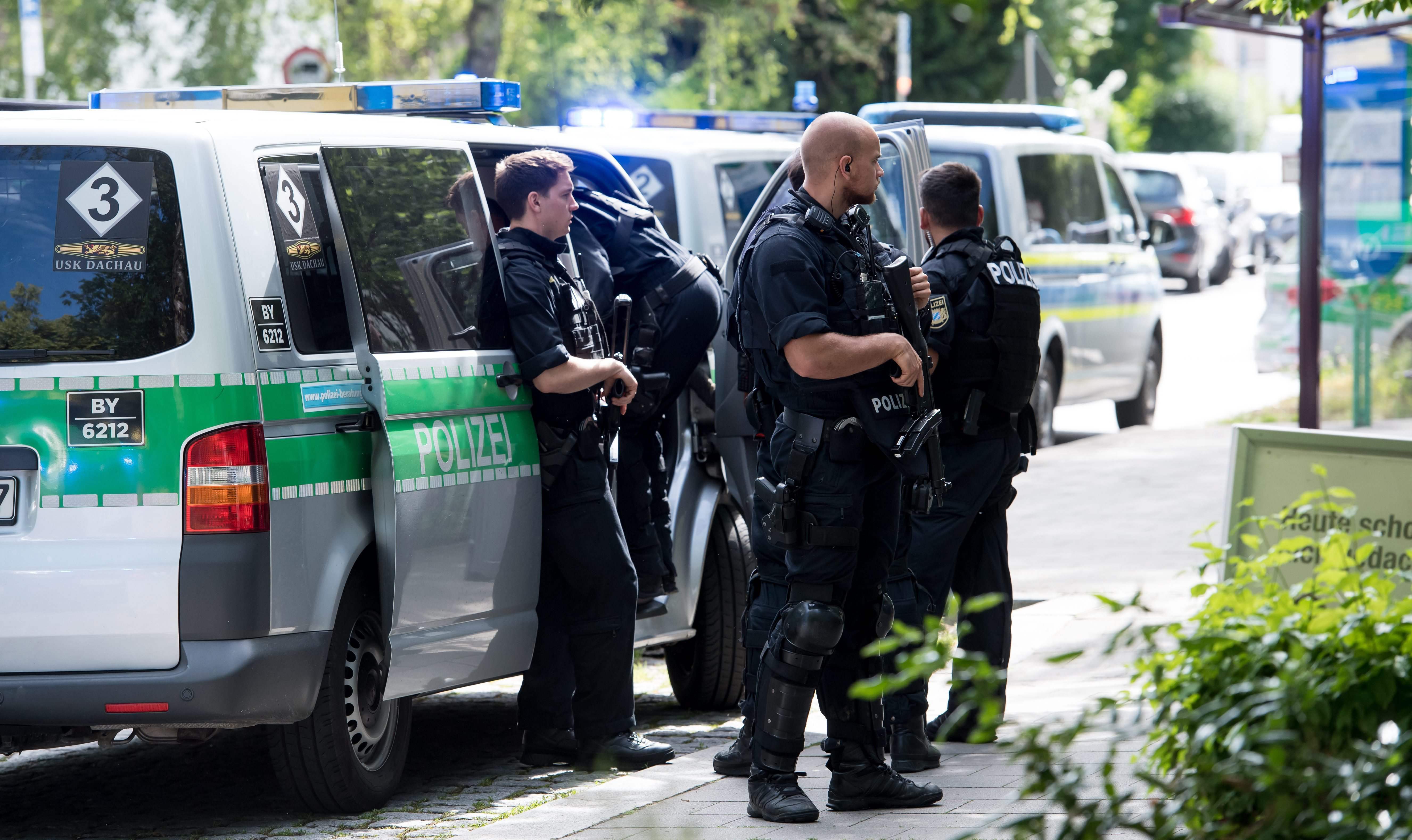 German police officer standing near a power substation in the Saxony region.