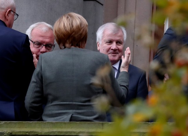 Leaders of the Christian Democratic Union of Germany (CDU) Angela Merkel and Christian Social Union (CSU) Bavaria State Premier Horst Seehofer are seen on a balcony of German Parliamentary Society offices before the exploratory talks about forming a new coalition government held by CDU/CSU in Berlin, Germany, October 26, 2017. Credit: Reuters