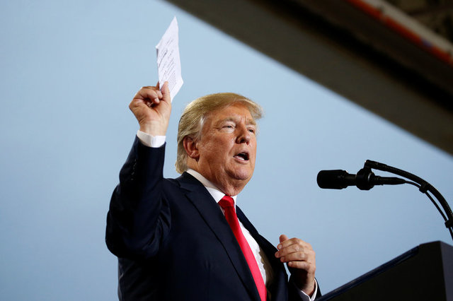 US President Donald Trump holds up a list of politicians as he speaks about tax reform in Harrisburg, Pennsylvania, U.S., October 11, 2017. Credit: Reuters