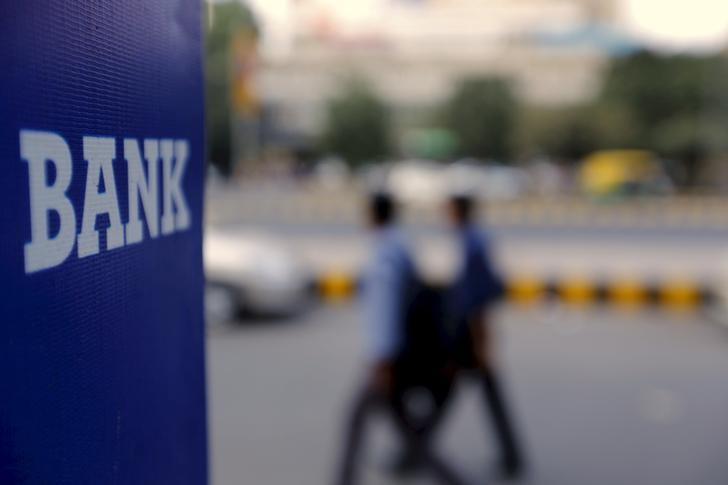 Commuters walk past a bank sign along a road in New Delhi in this November 25, 2015 file photo. Credit: Reuters/Anindito Mukherjee/Files