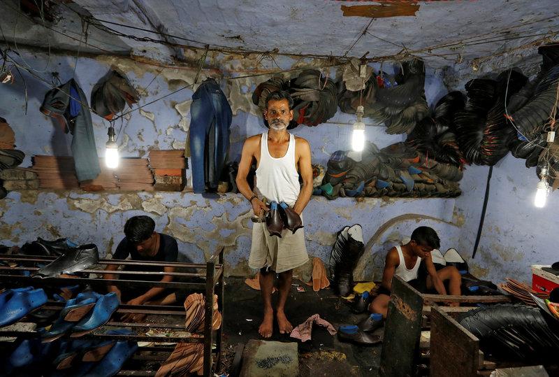 A shoemaker poses for a picture in an underground workshop in Agra, India, June 9, 2017. Credit: Reuters