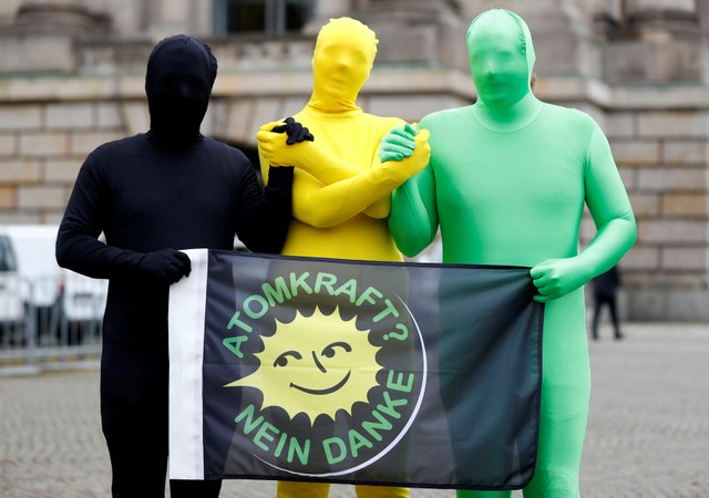 Environmental activists pose for photographers near the German Parliamentary Society offices during the exploratory talks about forming a new coalition government held by CDU/CSU in Berlin, Germany, October 26, 2017. The words read "Nuclear power? No thank you." Credit: Reuters