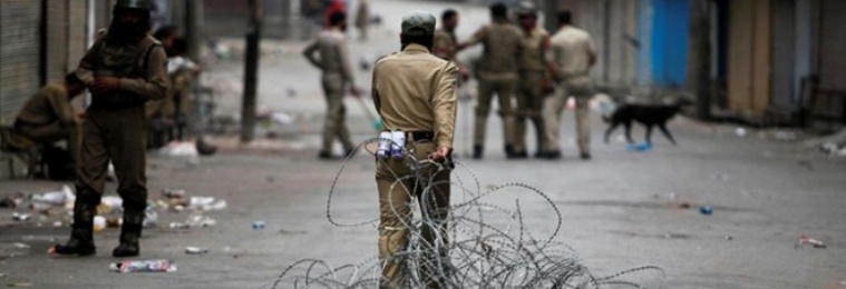 An Indian policeman pulls concertina wire to lay a barricade on a road during a curfew in Srinagar July 12, 2016. REUTERS/Danish Ismail - RTSHIRO