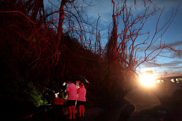 Local residents collect water from a broken pipe at an area damaged by Hurricane Maria, in Cayey, Puerto Rico, September 29, 2017. Credit: Reuters