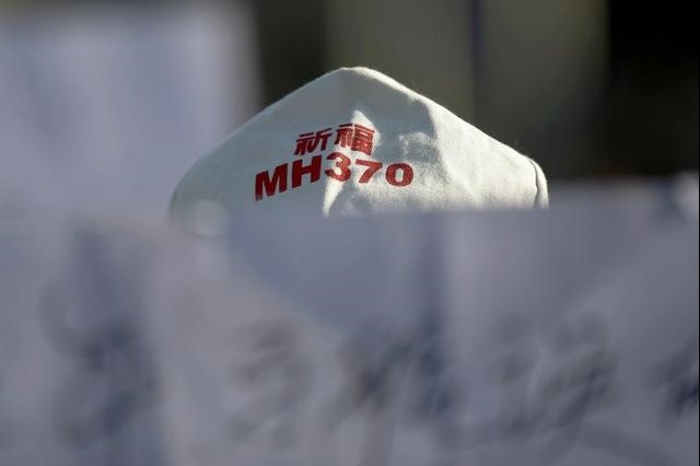 A family member of a passenger onboard Malaysia Airlines flight MH370 which went missing in 2014 holds a banner during a gathering in front of the Malaysian Embassy on the second anniversary of the disappearance of MH370, in Beijing, China, March 8, 2016. Credit: Reuters