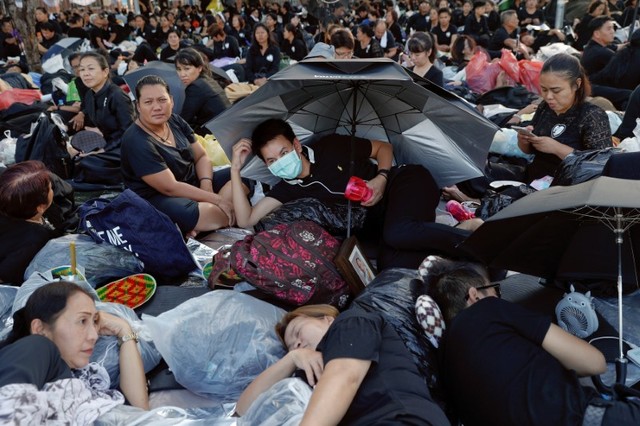 Mourners wait for tomorrow's Royal Cremation ceremony of Thailand's late King Bhumibol Adulyadej at the Grand Palace in Bangkok. Credit: Reuters