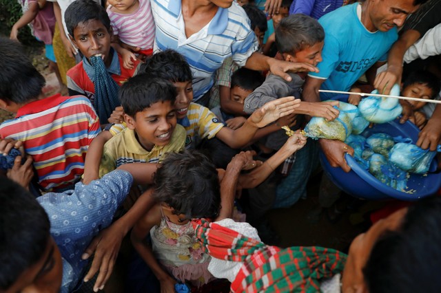 Refugee children scuffle over free meals given away during a wedding party for Rohingya refugees Saddam Hussein, 23, and Shofika Begum, 18, at the Kutupalong camp near Cox's Bazar, Bangladesh, December 11, 2017. Credit: Reuters/Damir Sagolj