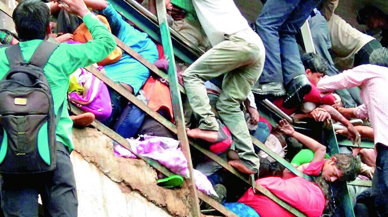 People try to rescue those stuck in the stampede on the Parel-Elphinstone foot over bridge. Credit: PTI/Files