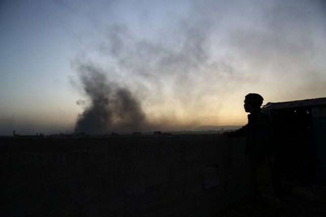 A man watches as smoke rises from Harasta area, as seen from Douma, in the eastern Damascus suburb of Ghouta, Syria November 14, 2017. Credit: Reuters/Bassam Khabieh/Files