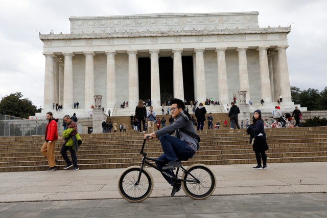 A man cycles in front of Lincoln Memorial in Washington, US, on the second day of Government shutdown, January 21, 2018. Credit: Reuters/Yuri Gripas