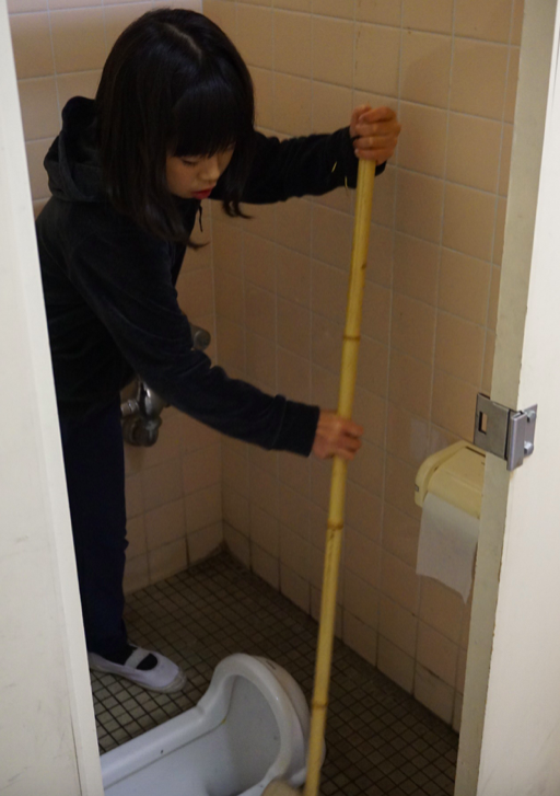 A girl cleaning a toilet at Kita-Yamada Elementary School in Osaka. Credit: Janaki Nair