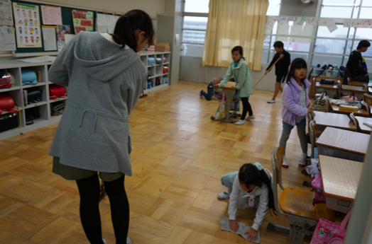 Students scrubbing a classroom floor. Credit: Janaki Nair