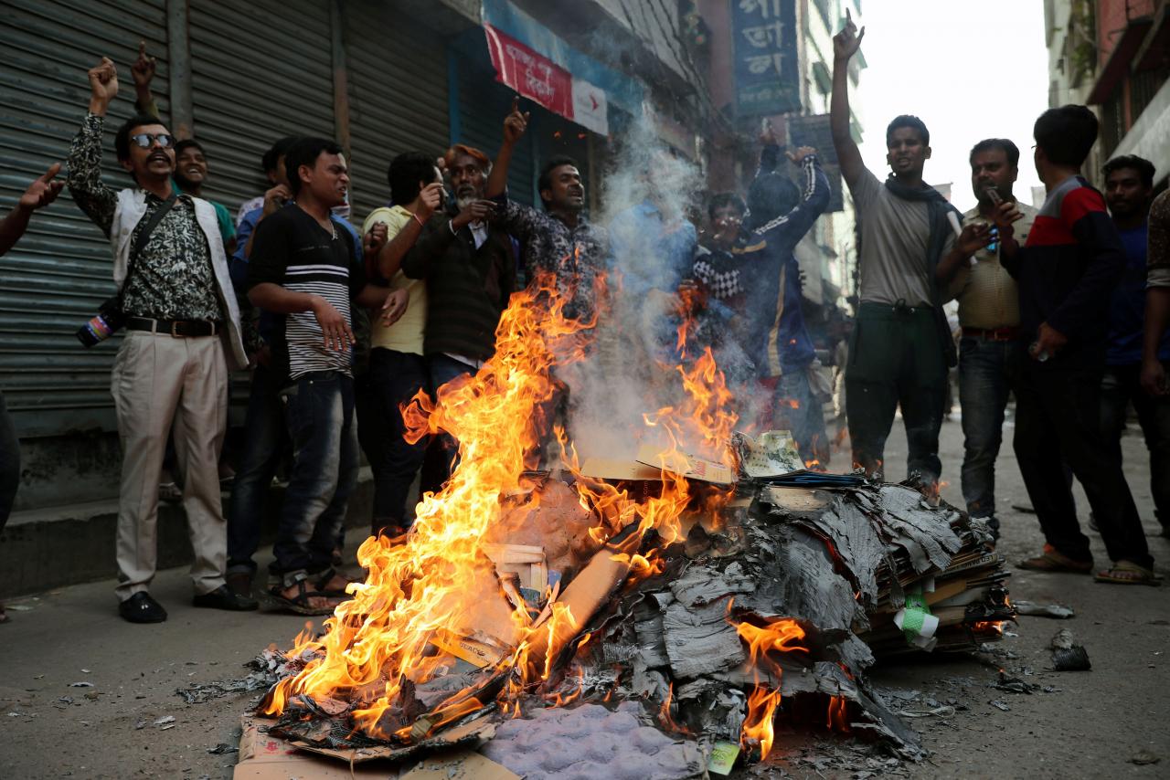 BNP supporters shout slogans as they set fire to posters during a protest in a street in Dhaka, Bangladesh on February 8, 2018. Credit: Reuters/Mohammad Ponir Hossain