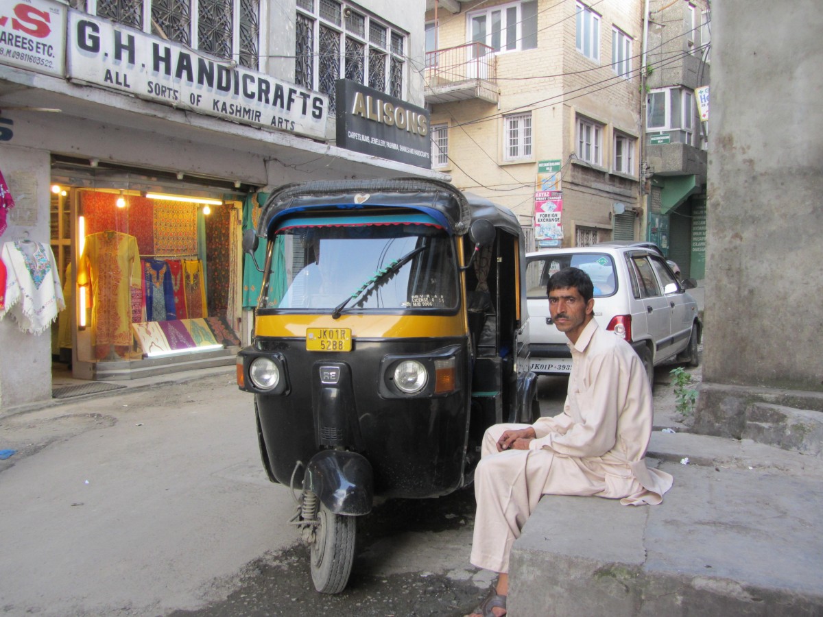 Ajaz waits for a passenger opposite a handicrafts outlet in Srinagar.