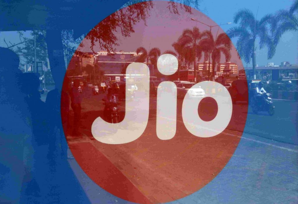 Commuters are reflected on an advertisement of Reliance Industries' Jio telecoms unit, at a bus stop in Mumbai, India, February 21, 2017. Credit: Reuters/Shailesh Andrade