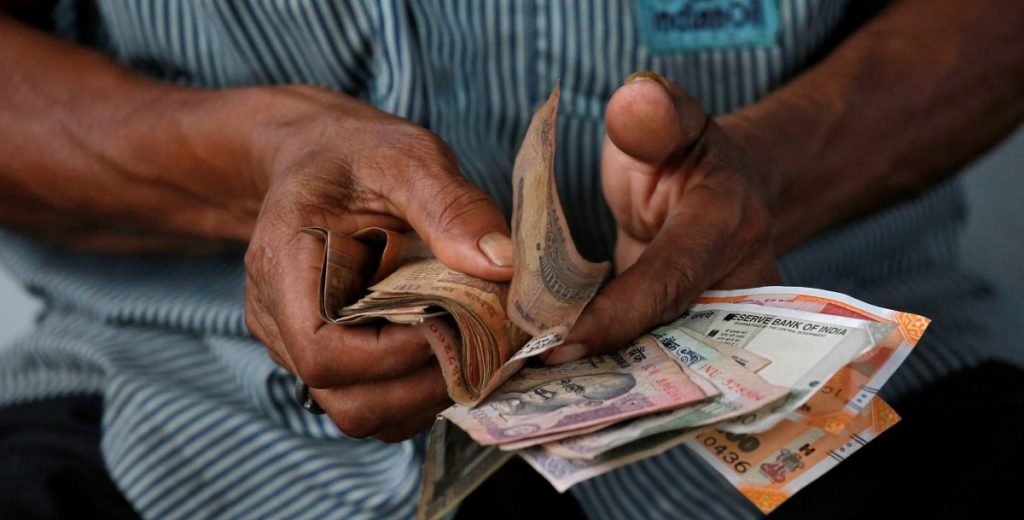 An attendant at a fuel station arranges Indian rupee notes in Kolkata, August 16, 2018. Credits: Reuters/Rupak De Chowdhuri/File Photo